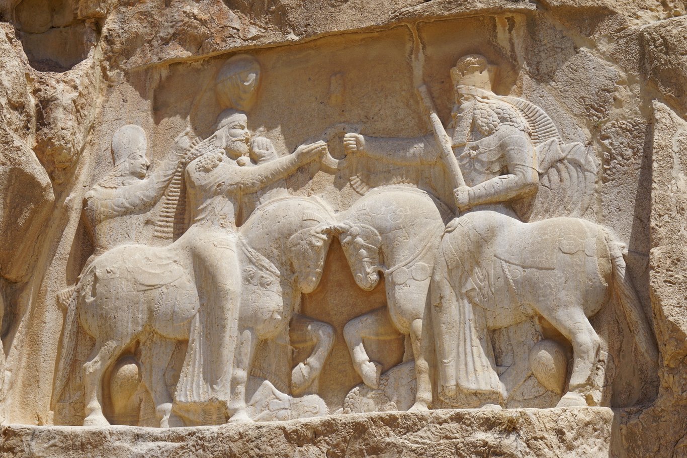 Su questo bassorilievo, Ardashir I riceve il simbolo de la reygalità da las mani divine di Ahura Mazda
